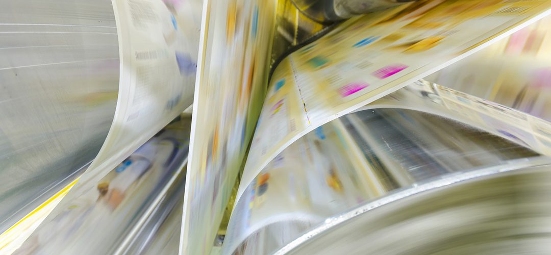 Print machine offset A large webset offset printing press running a long roll off paper over its rollers at high speed.